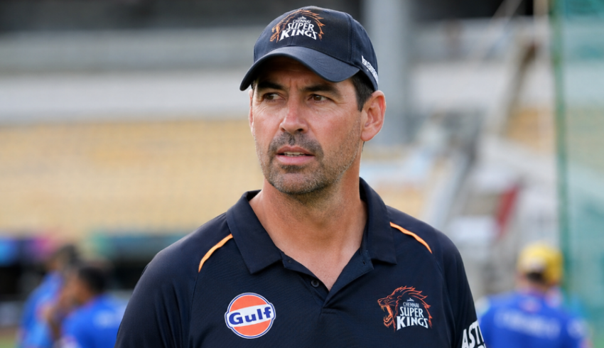 Cricket coach Stephen Fleming stands beside a practice field during a team training session