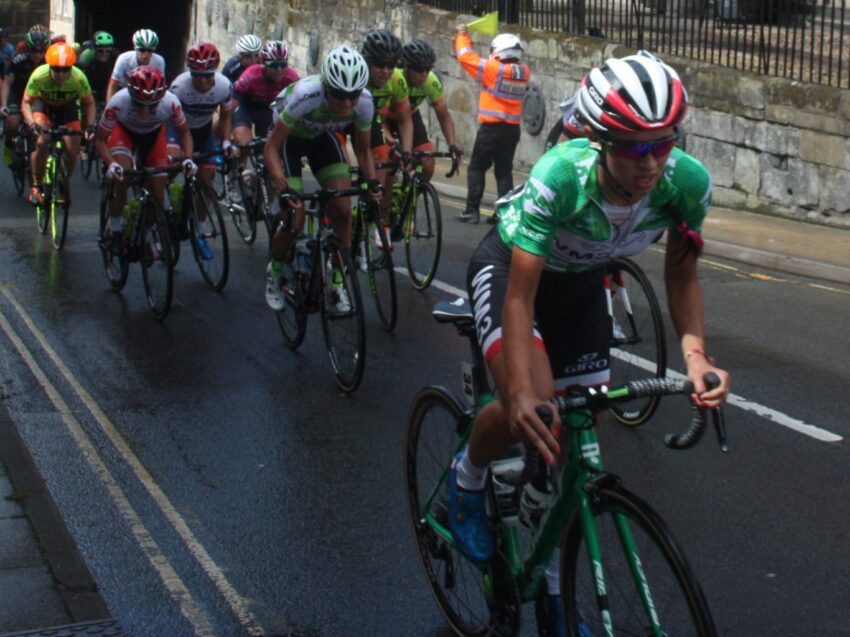Kasia Niewiadoma, in the race leader's green jersey, rides through Warwick with the peloton during stage 3 of the 2017 Women's Tour.