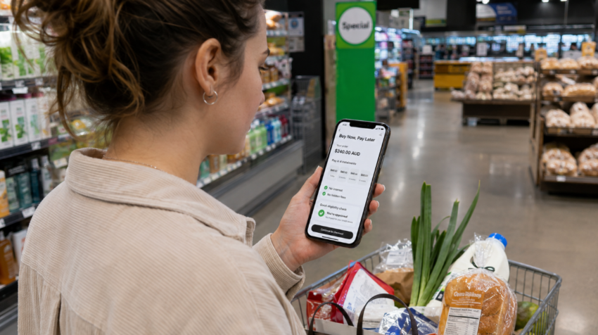 Australian shopper using a buy now, pay later app on a smartphone while buying groceries in a supermarket.