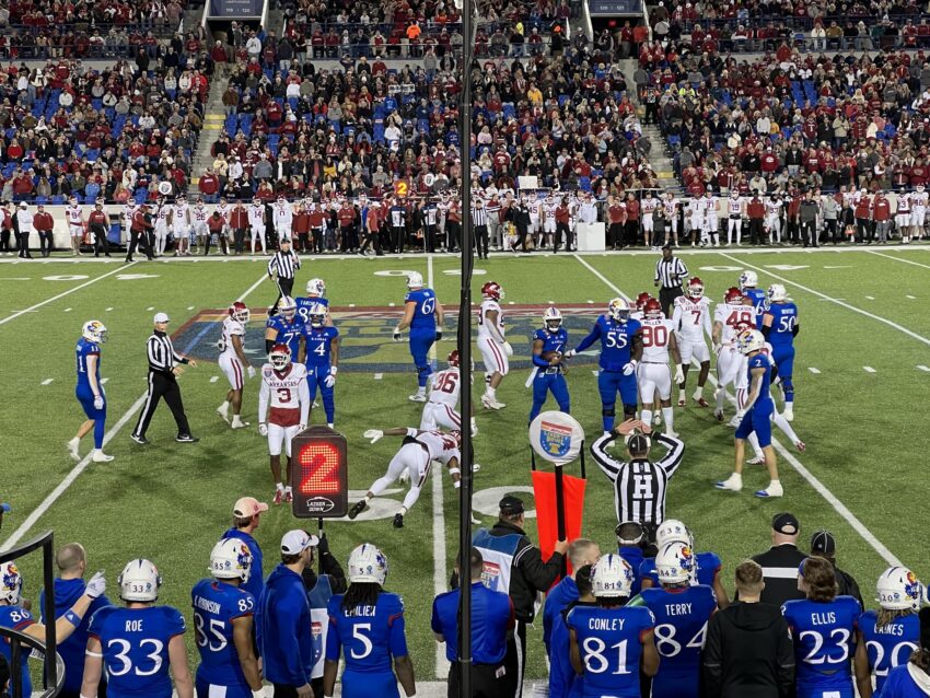 Kansas quarterback Jalon Daniels (uniform No. 6, blue) gains a first down against Arkansas (white) during the second quarter of the 2022 Liberty Bowl at Simmons Bank Liberty Stadium in Memphis, Tennessee.