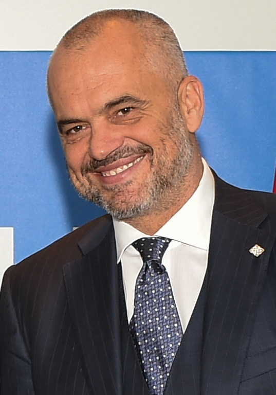 U.S. Secretary of State John Kerry shakes hands with Albanian Prime Minister Edi Rama as Albanian Foreign Minister Ditmir Bushati looks on before a bilateral meeting on September 5, 2014, on the sidelines of the NATO Summit in Newport, Wales, United Kingdom. [State Department photo/ Public Domain]