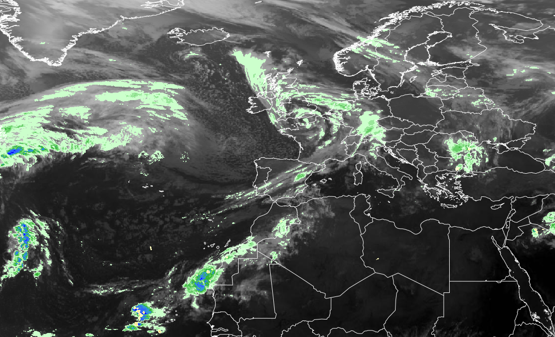 Satellite image showing cloud formations over the North Atlantic Ocean and Europe, including the British Isles, with enhanced precipitation areas highlighted in green and blue.